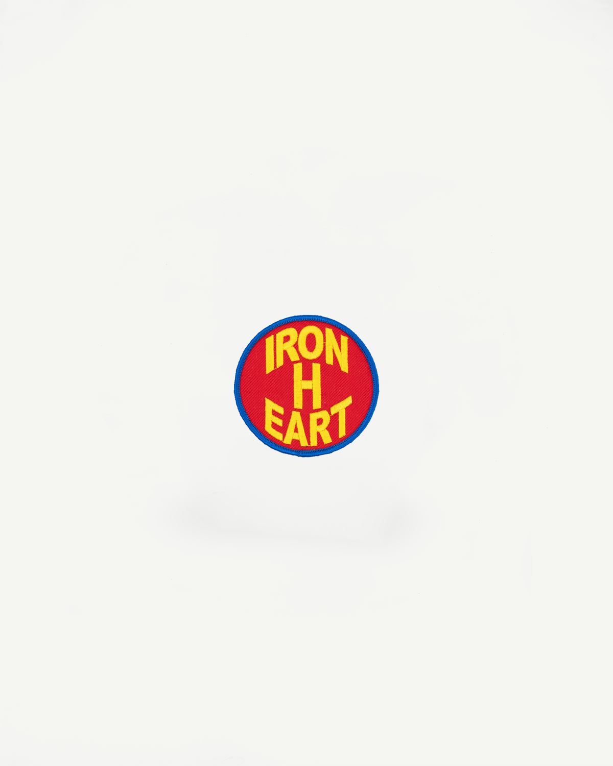 Iron Heart embroidered patch, red background, yellow text, blue border, front view close-up