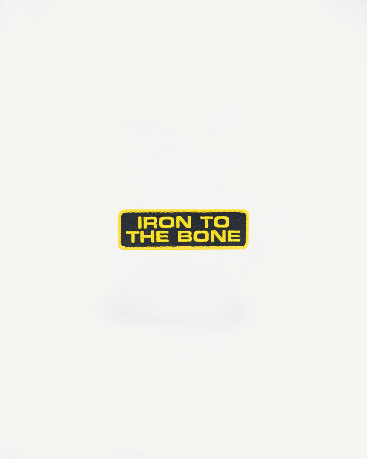 Iron To The Bone embroidered patch, yellow text on black background, front view close-up