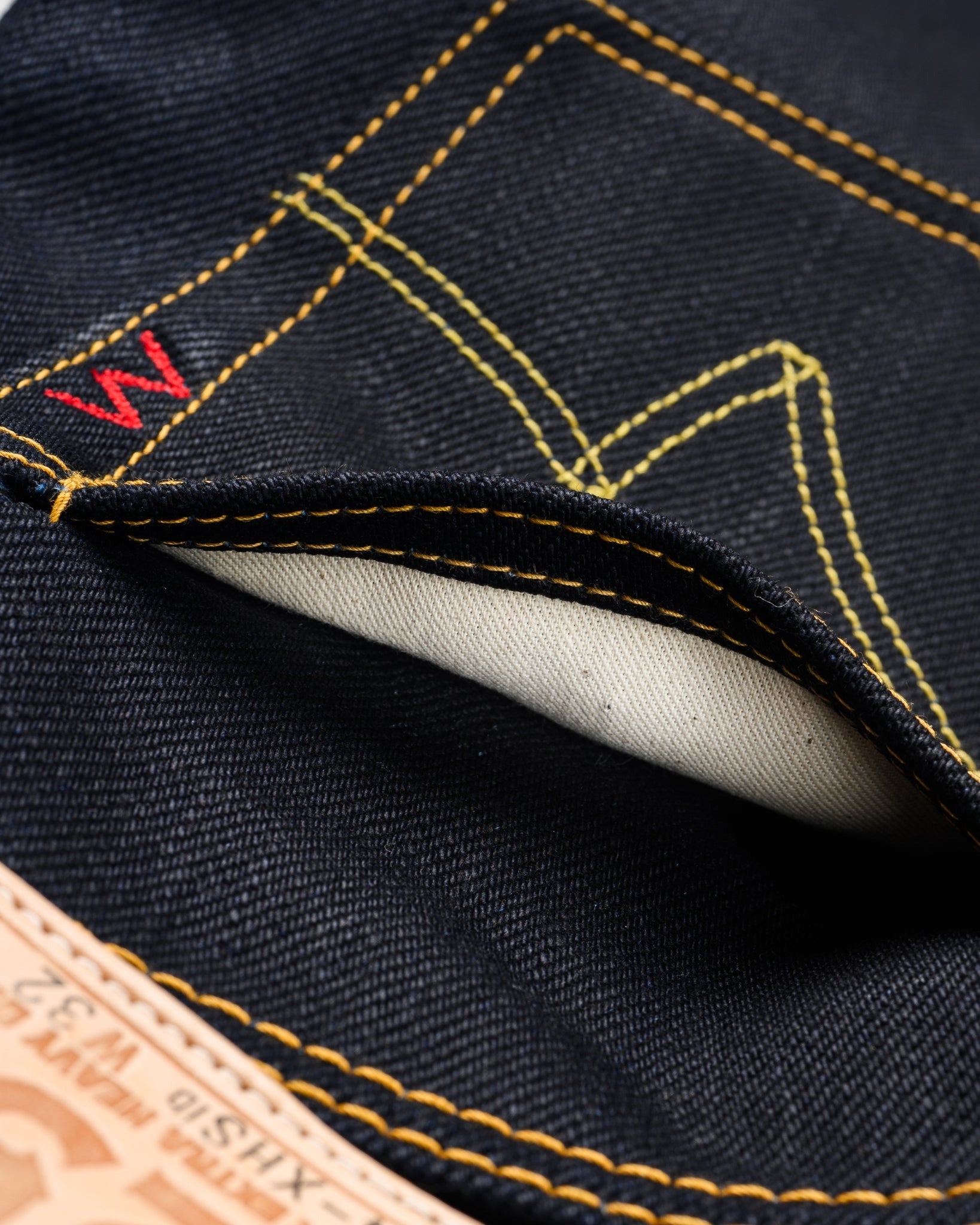 Close-up of Iron Heart 25oz selvedge denim jeans back pocket stitching, leather patch, and pocket edge detail
