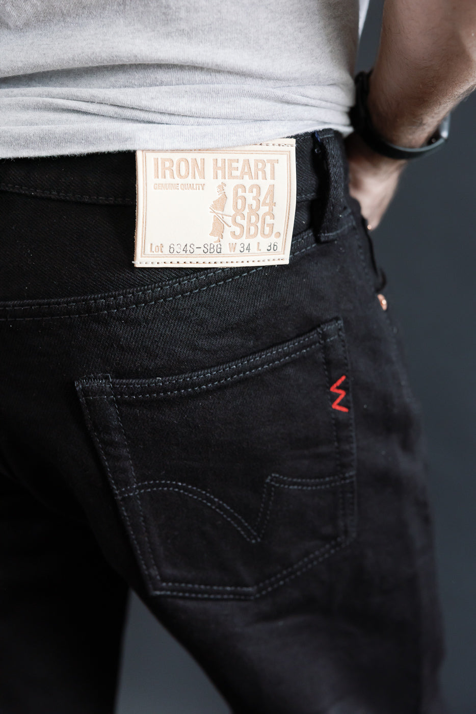 Close-up of Iron Heart 634 SBG 21oz superblack selvedge denim jeans back, leather patch, on male model 5'9