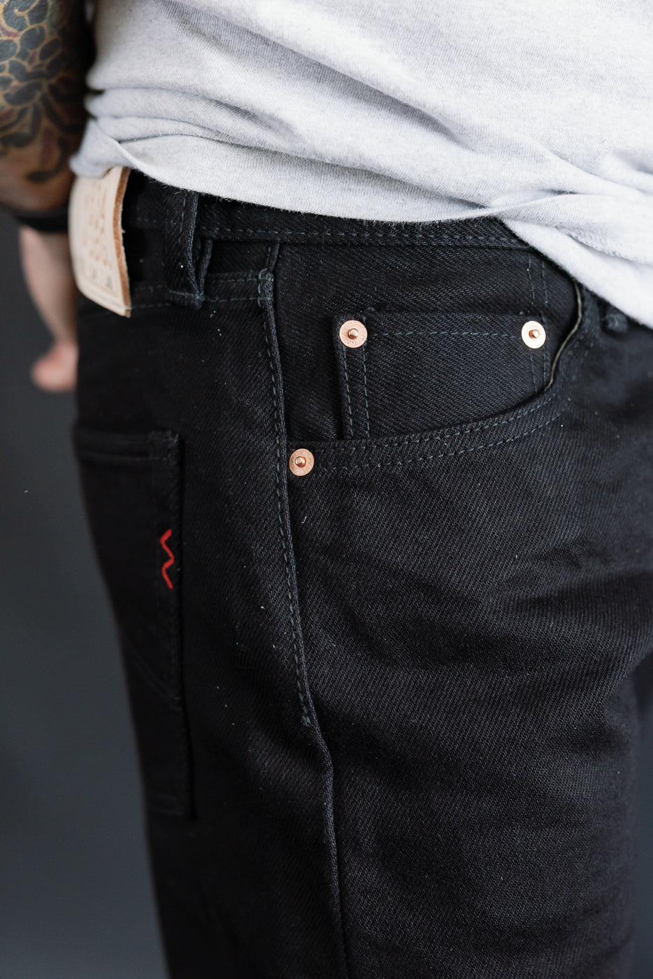 Close-up of Iron Heart IH-634S 21oz superblack selvedge denim front pocket and rivets on male model, 5'9