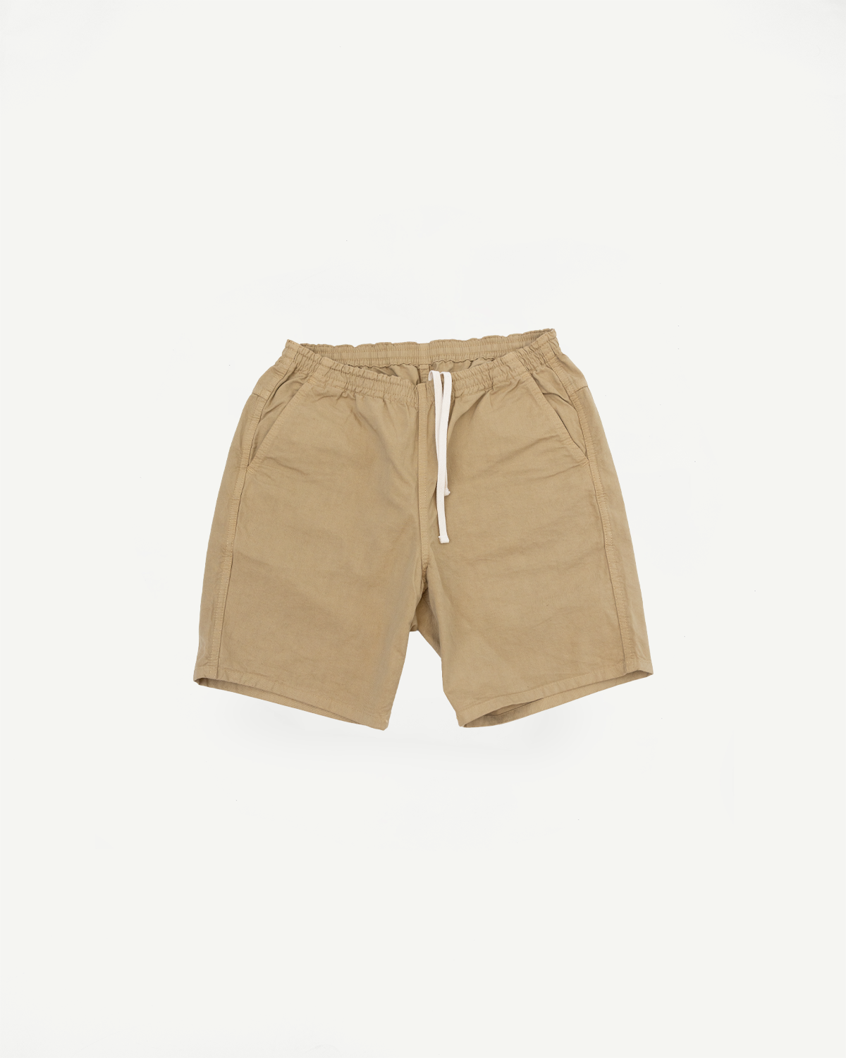 Front view of beige drawstring shorts with elastic waistband, flat lay