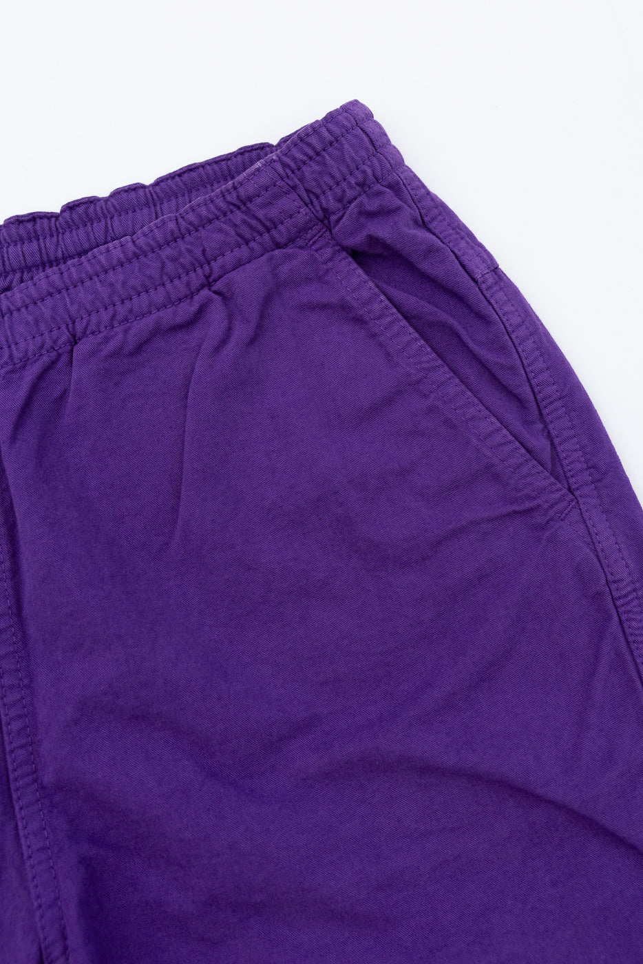 Close-up front view of purple casual shorts showing elastic waistband and fabric texture