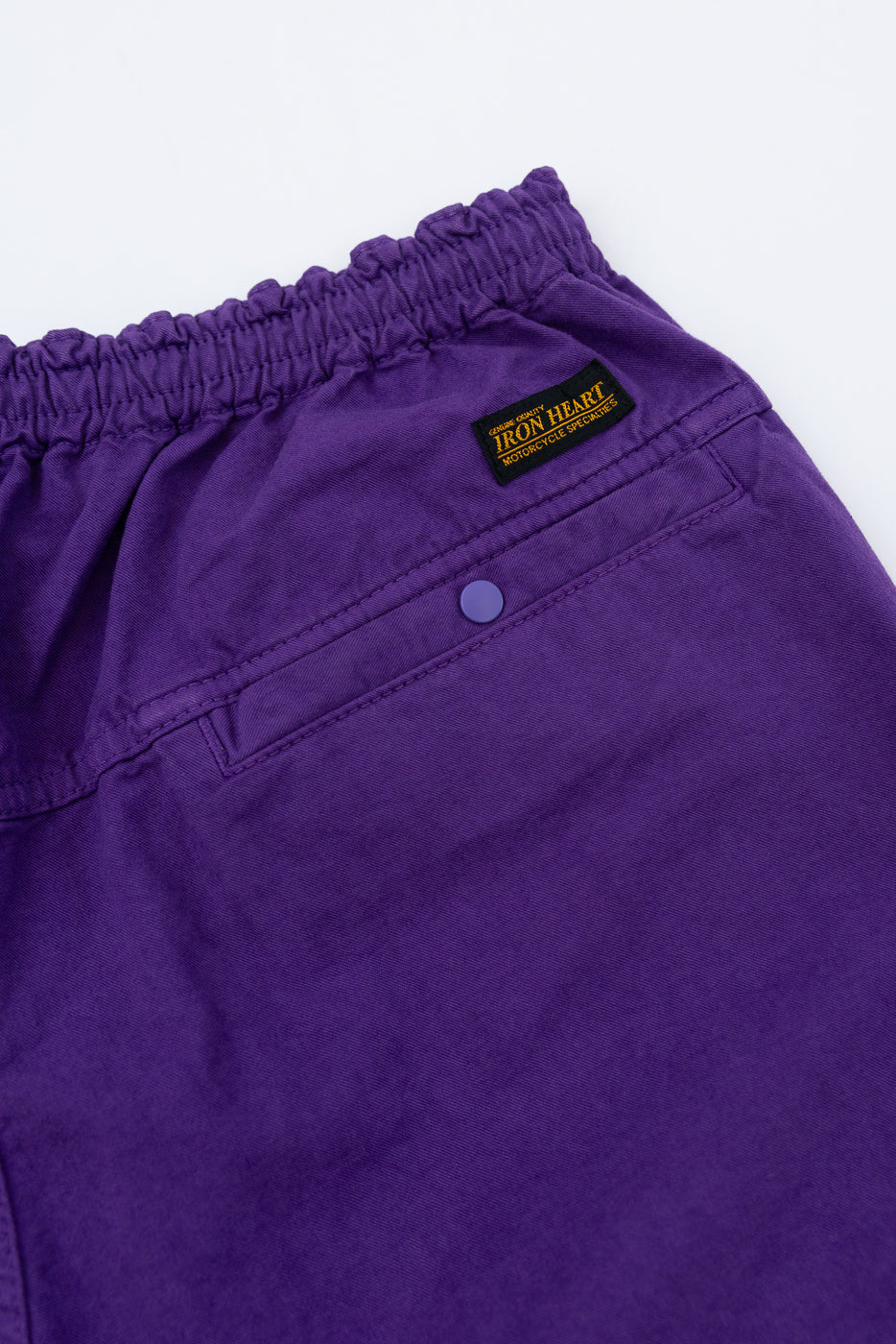 Purple chino shorts close-up, front view, elastic waist, button detail, Iron Heart tag