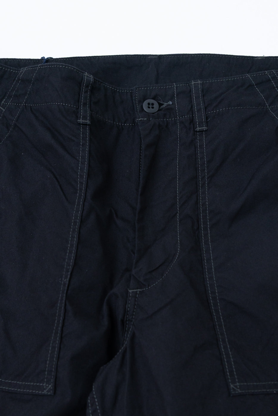 Close-up front view of dark navy casual pants with button fly and contrast stitching details