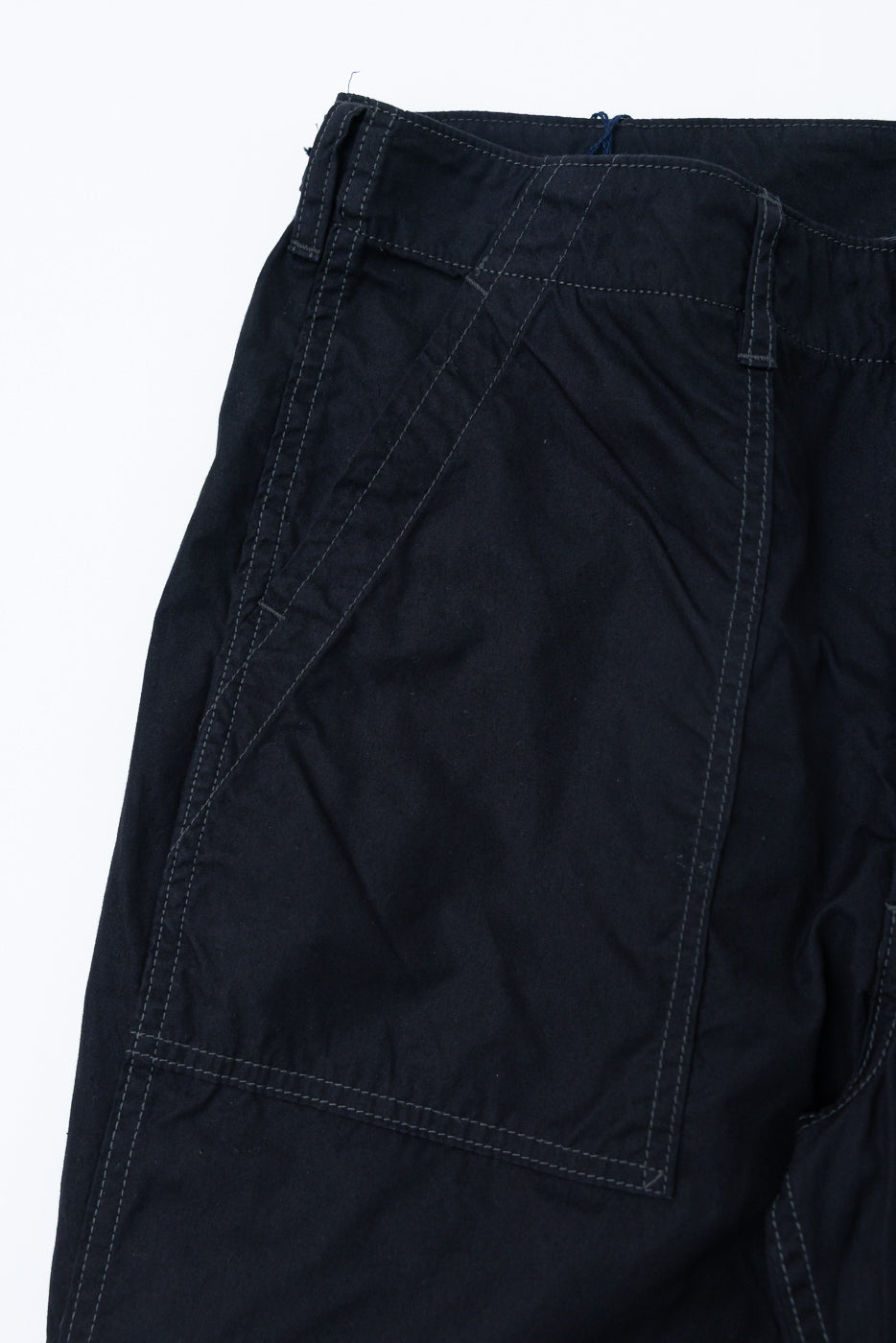 Close-up front view of dark selvedge pants, showcasing diagonal stitching and fabric texture