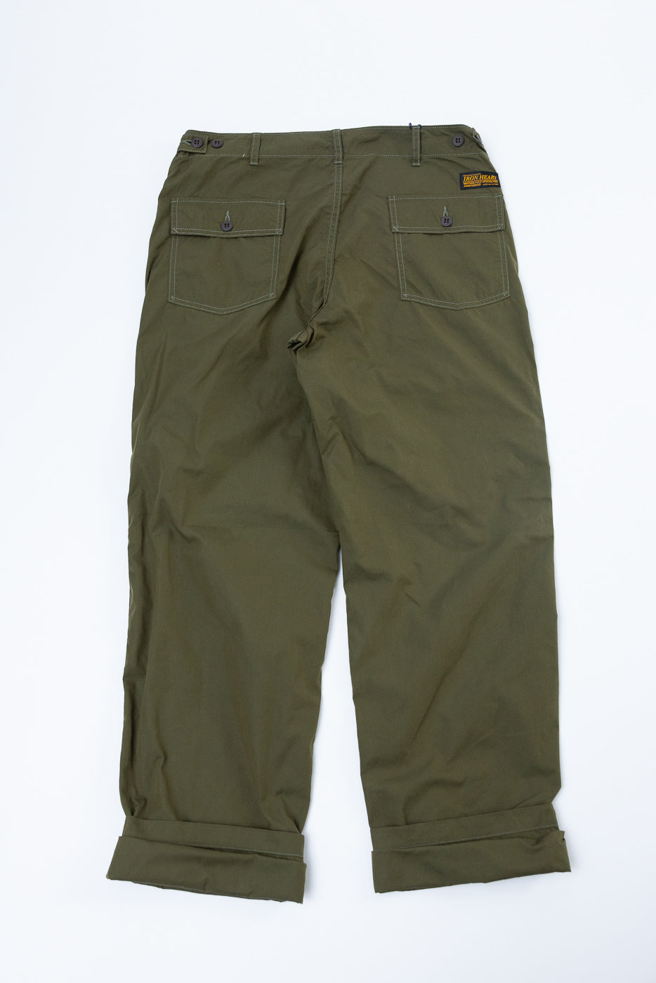 Back view of olive green cargo pants with buttoned pockets, rolled hems, and brand tag