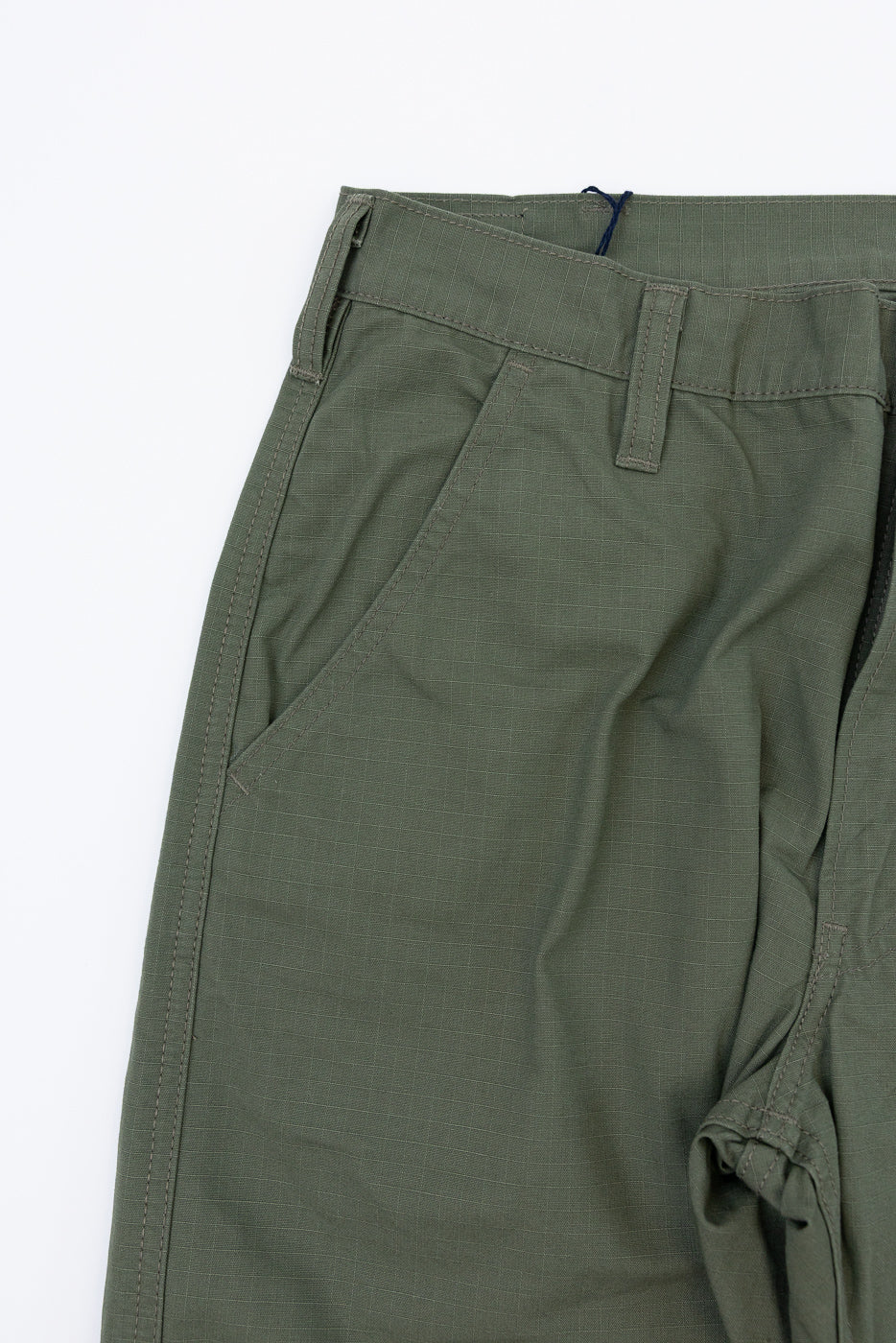 Olive green casual pants close-up, front view showing waistband, belt loop, and diagonal pocket detail