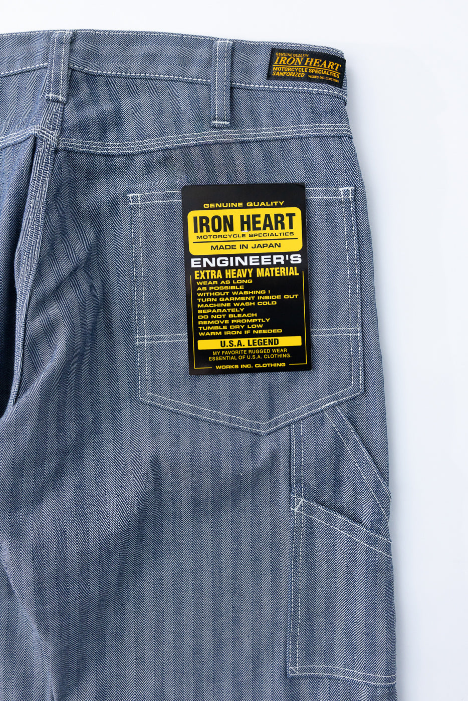 Iron Heart Engineer's extra heavy material denim pants, back view flat lay, showing herringbone texture, white stitching, and brand tag details.