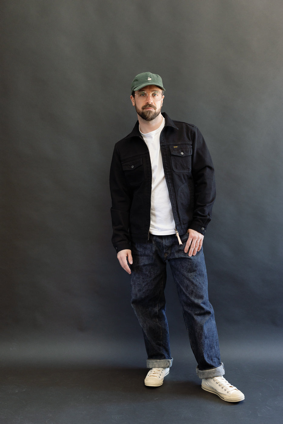 Man models the IHJ-123-OD - 14oz Broken Twill Selvedge Denim Work Jacket - Indigo Overdyed Black, featuring a black denim style, with relaxed fit and quality construction, embodying Dant's premium menswear ethos.