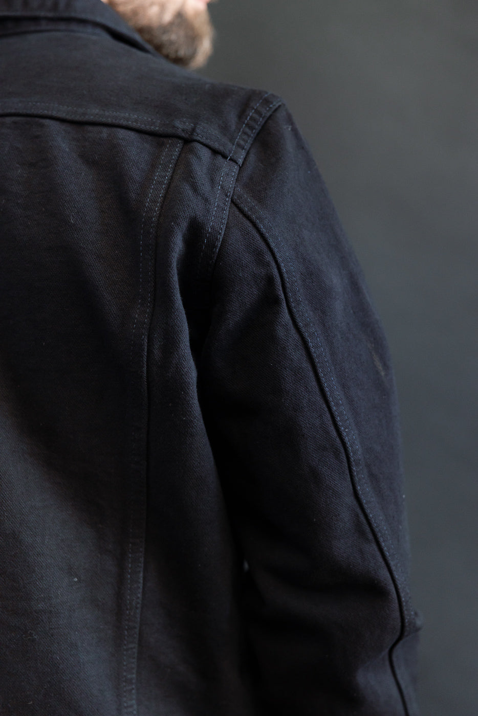 Close-up of the IHJ-123-OD - 14oz Broken Twill Selvedge Denim Work Jacket, highlighting its meticulous stitching and seam details on dark denim, reflecting premium craftsmanship and heritage style.