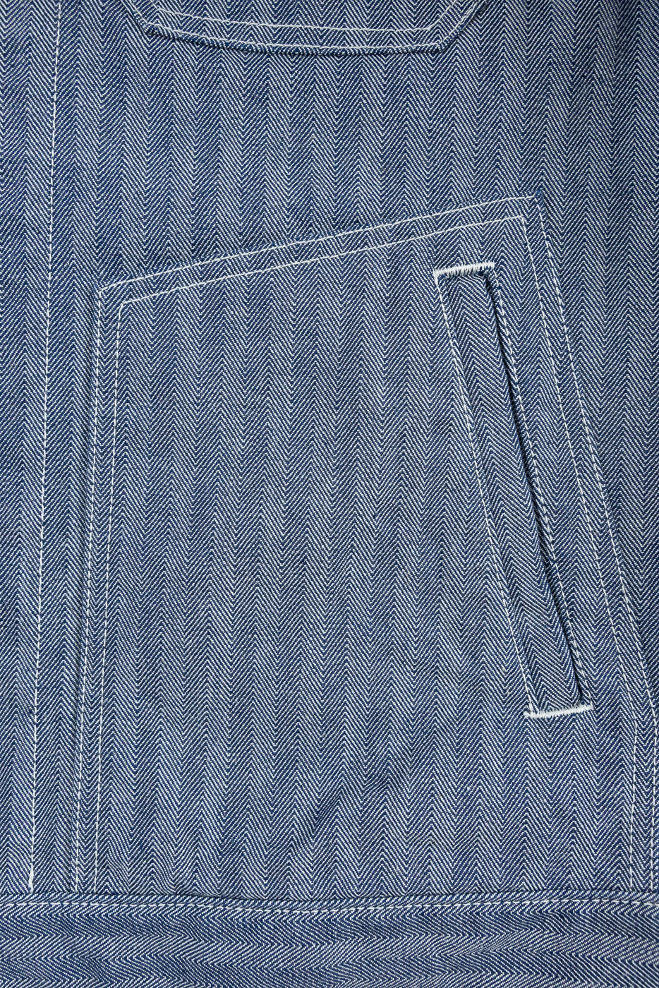 Close-up of front pocket and herringbone texture on indigo work jacket, front side detail