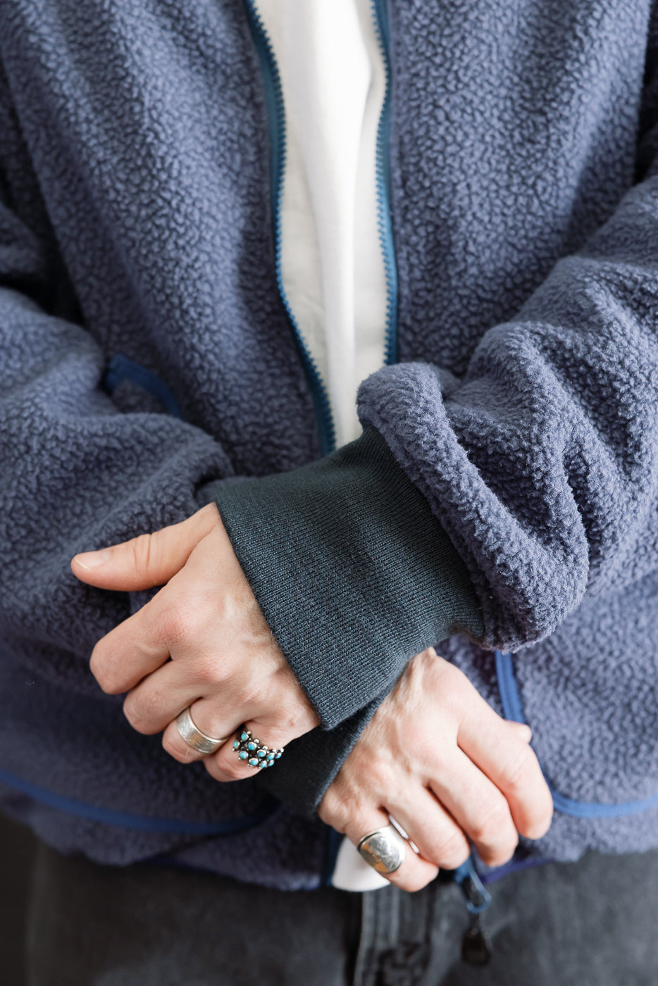 Close-up of male model's hands showing navy reversible fleece jacket front cuff details, size 5'9