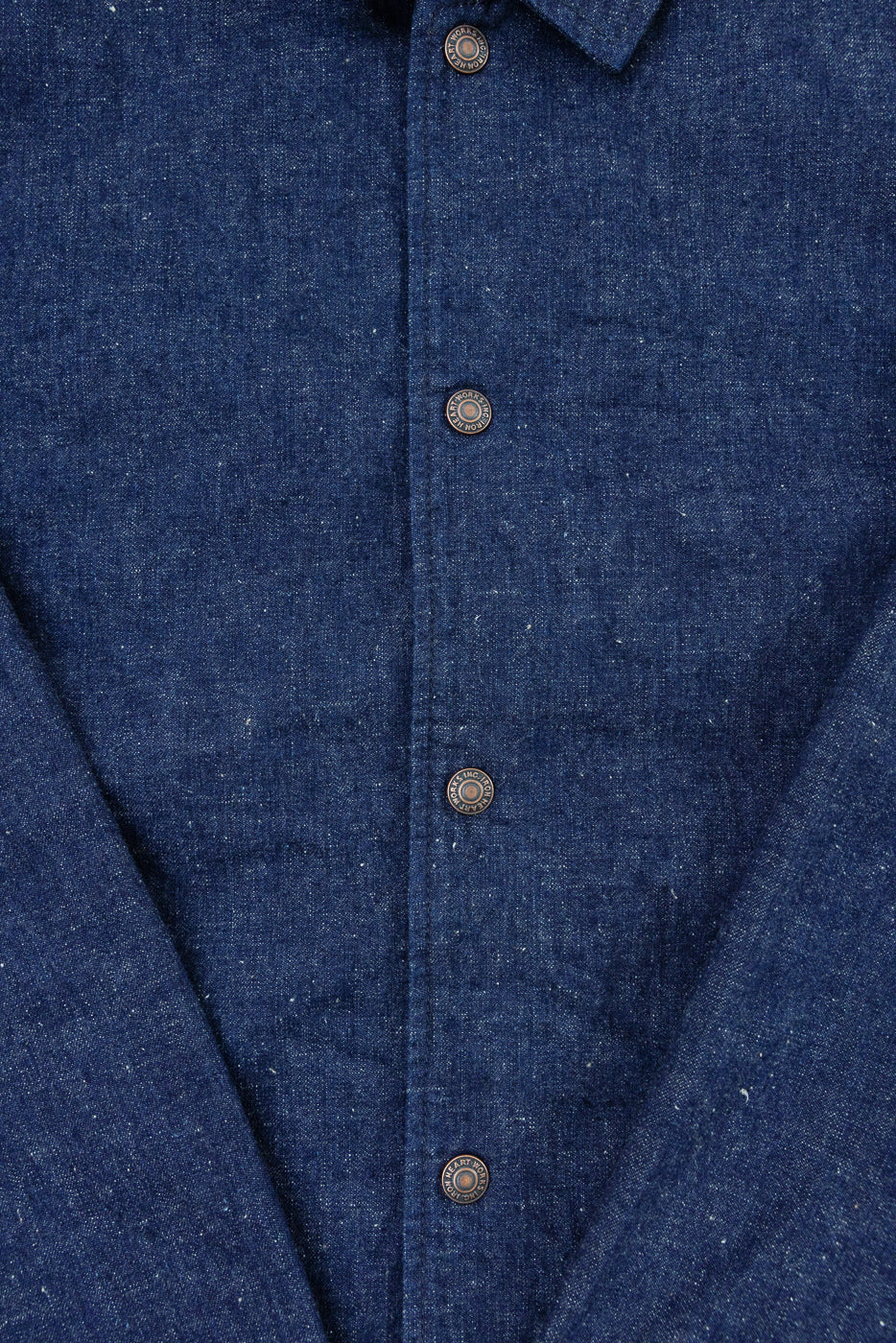 Close-up front view of dark blue denim shirt showing button placket, texture, and collar detail