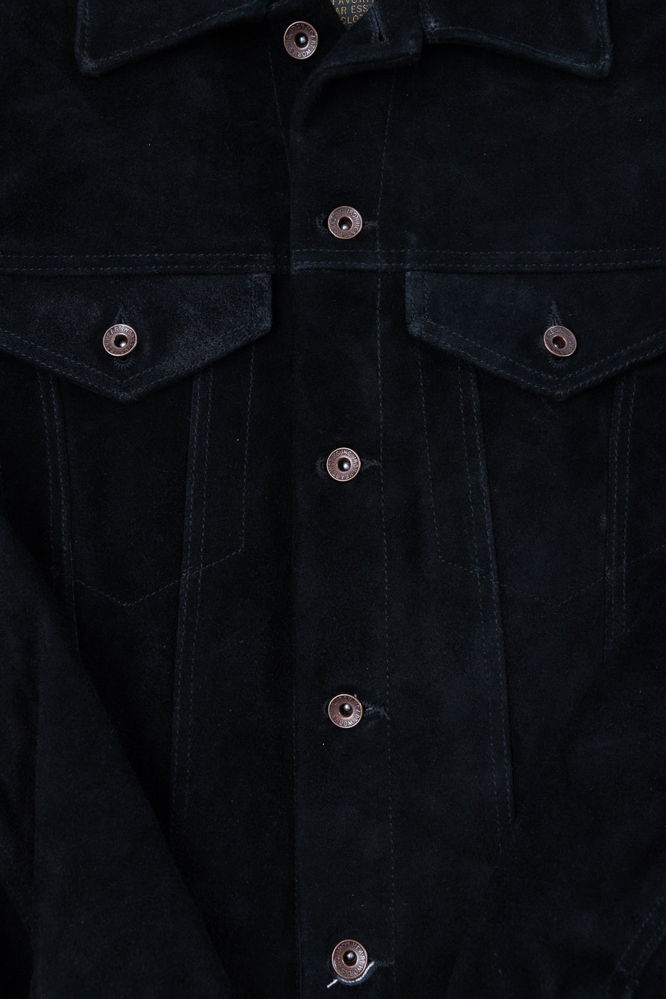 Close-up front of black suede jacket with copper buttons, flap pockets, and collar detail