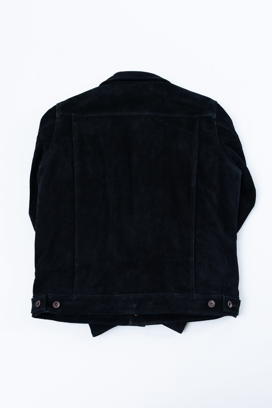 Back view flat lay of black corduroy jacket with snap buttons, showing texture and hem detail