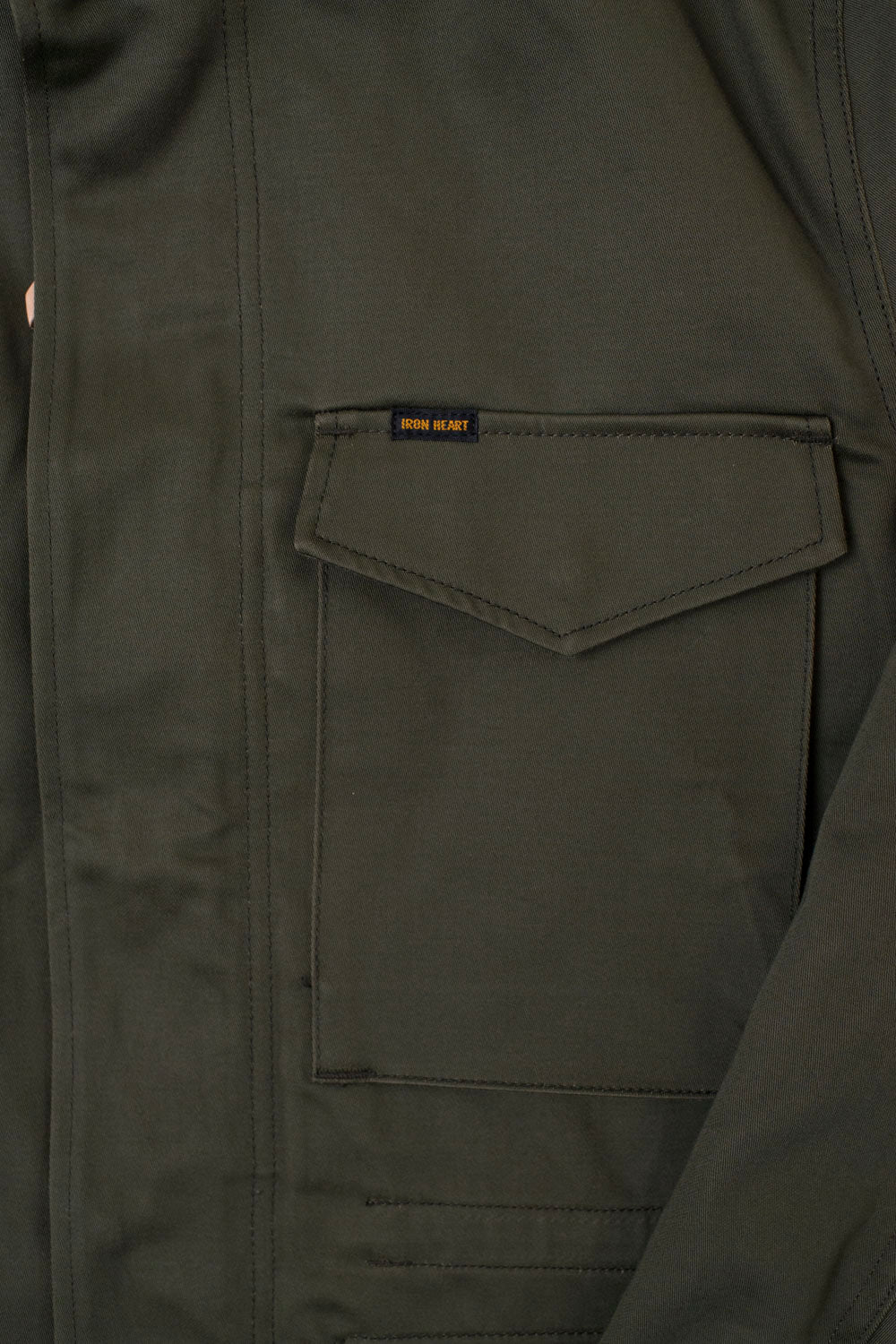 Close-up of Iron Heart olive sateen M65 field jacket front pocket detail and fabric texture