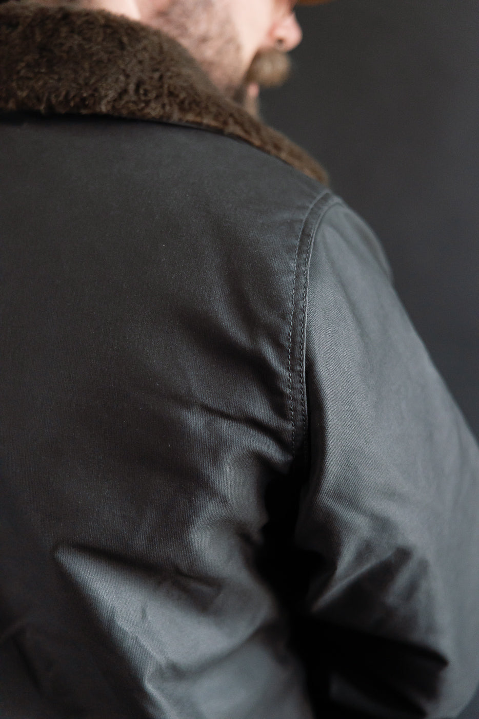 Close-up of back left shoulder and collar of Iron Heart black oiled whipcord N1 deck jacket on 5'9