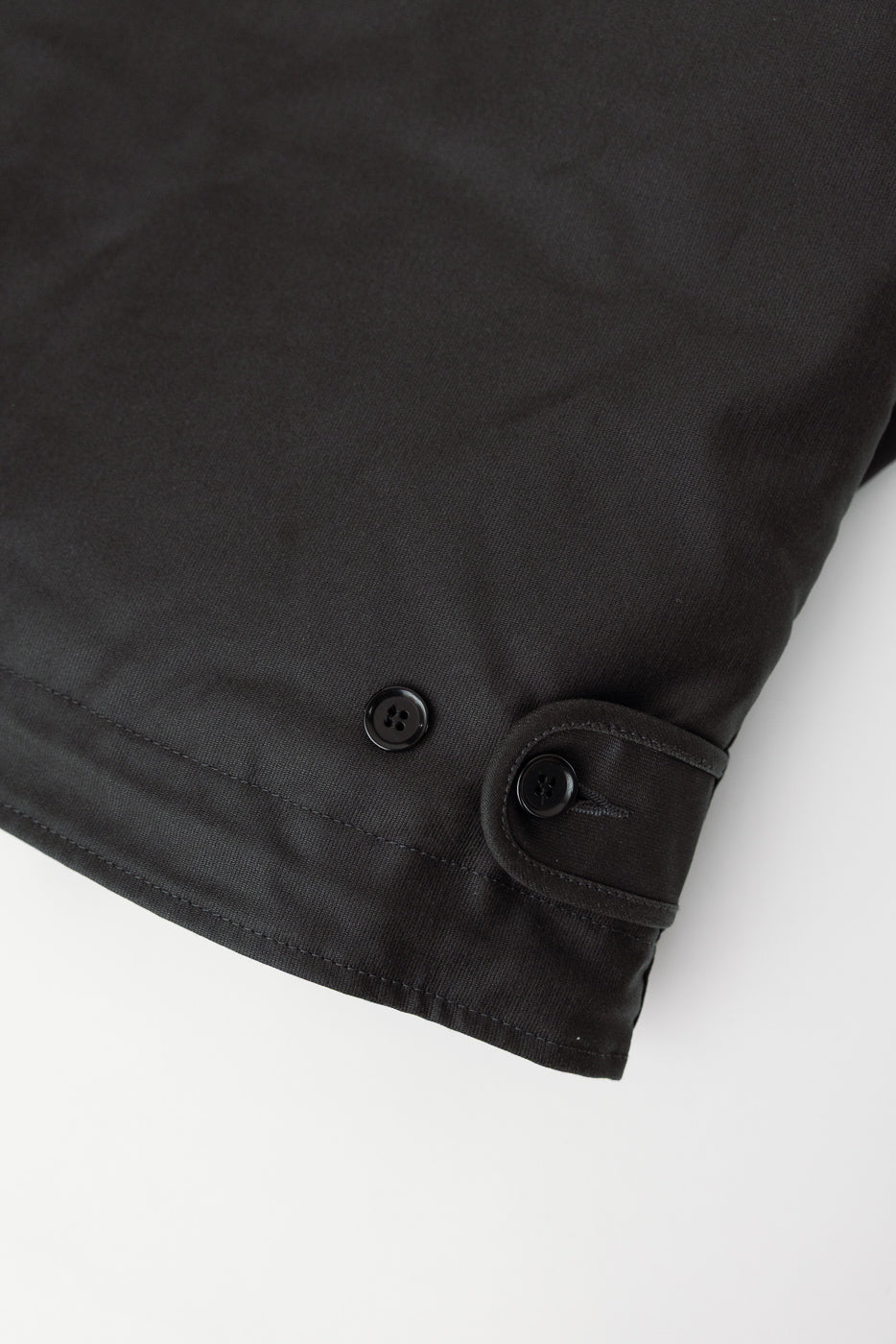 Close-up of Iron Heart black oiled whipcord N1 Deck Jacket front hem detail with buttons
