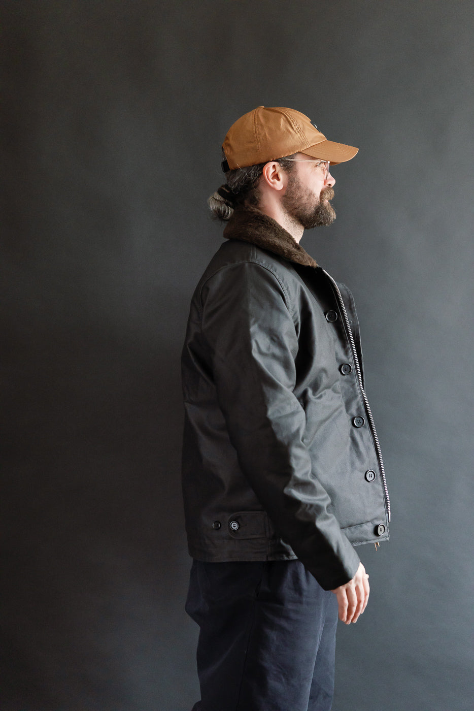 Male model 5'9 165lbs athletic build wearing Iron Heart black N1 Deck Jacket, side view