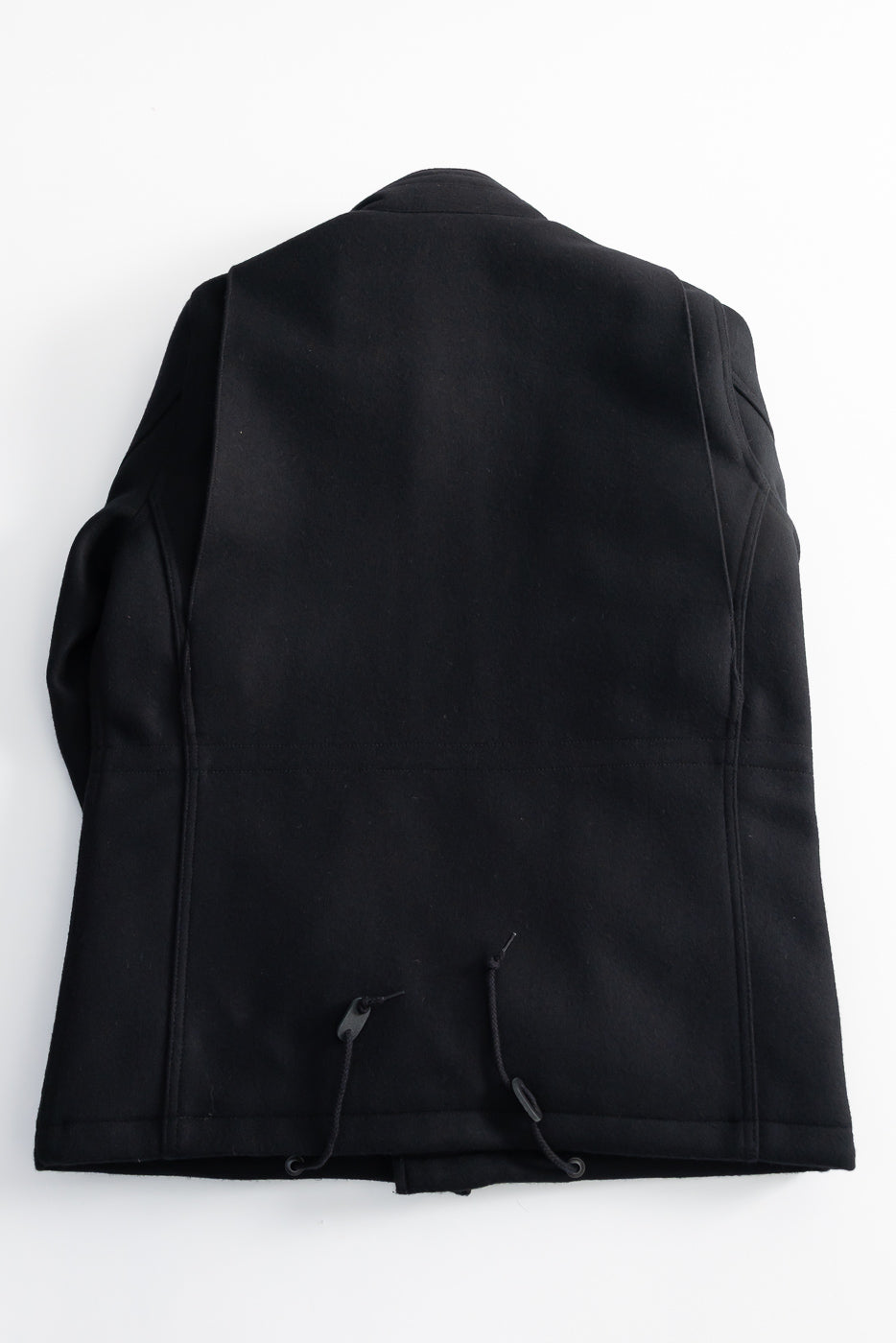 Flat lay of Iron Heart IH M-65 Melton wool field jacket, rear view, black with drawstring hem