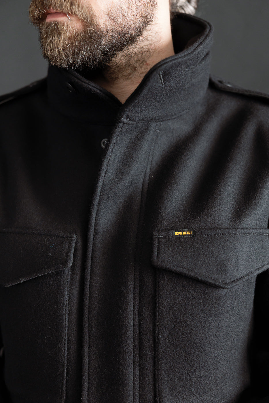 Close-up front detail of Iron Heart black Melton wool M65 jacket, chest pockets, male model 5'9