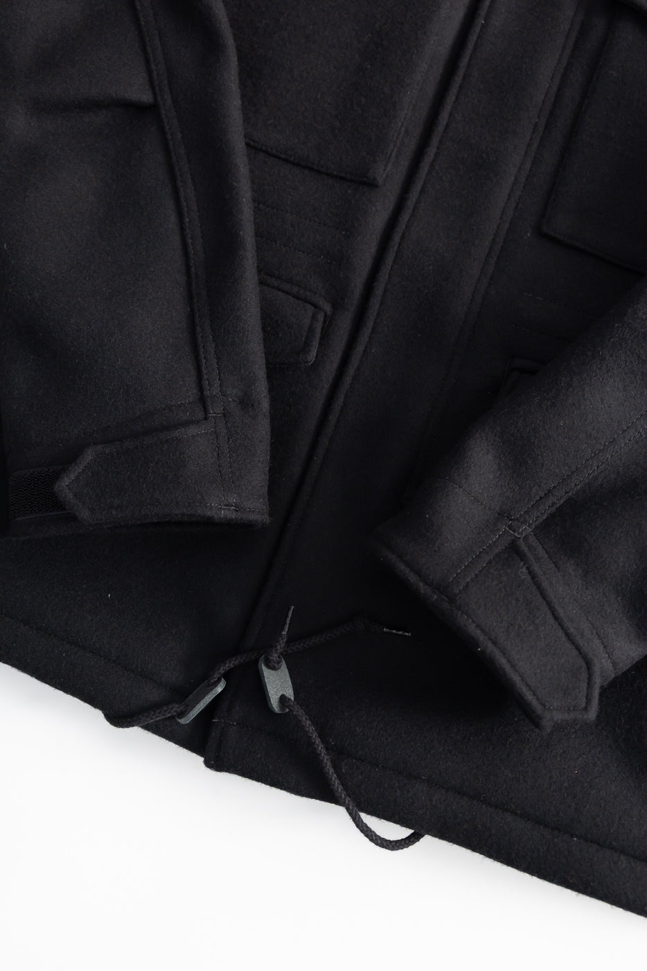 Close-up of Iron Heart IHJ-49-BLK M65 field jacket front hem, black melton wool, drawcord detail.