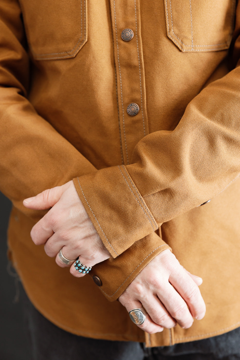 Close-up of front torso and sleeves of brown duck work shirt on male model, 5'9