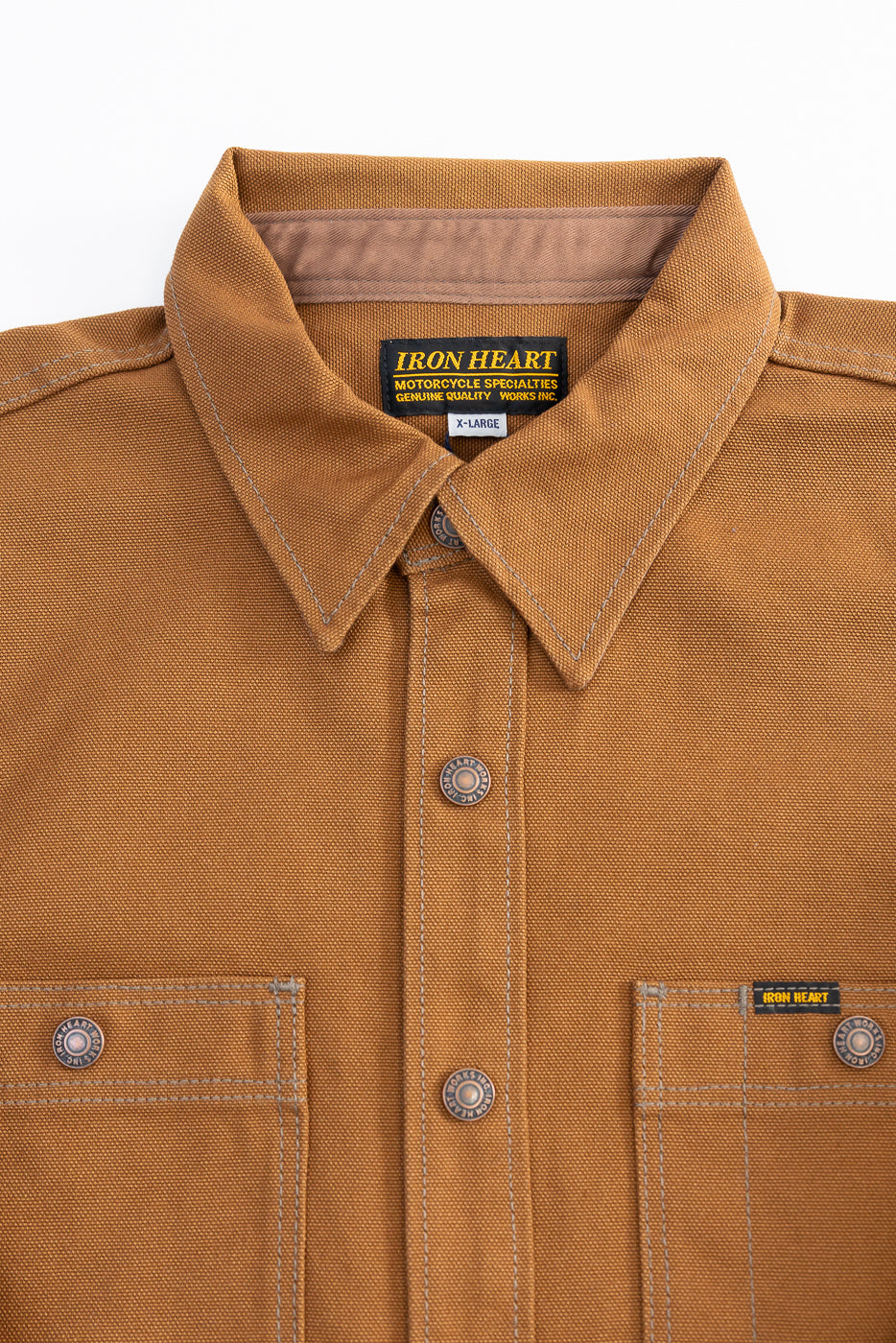 Close-up of front upper chest on brown duck work shirt, showing buttons, collar, and pockets.