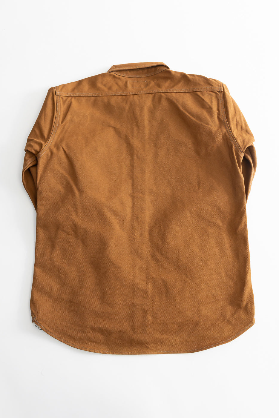 Flat lay of brown duck canvas work shirt, back view, showing curved hem and yoke detail.