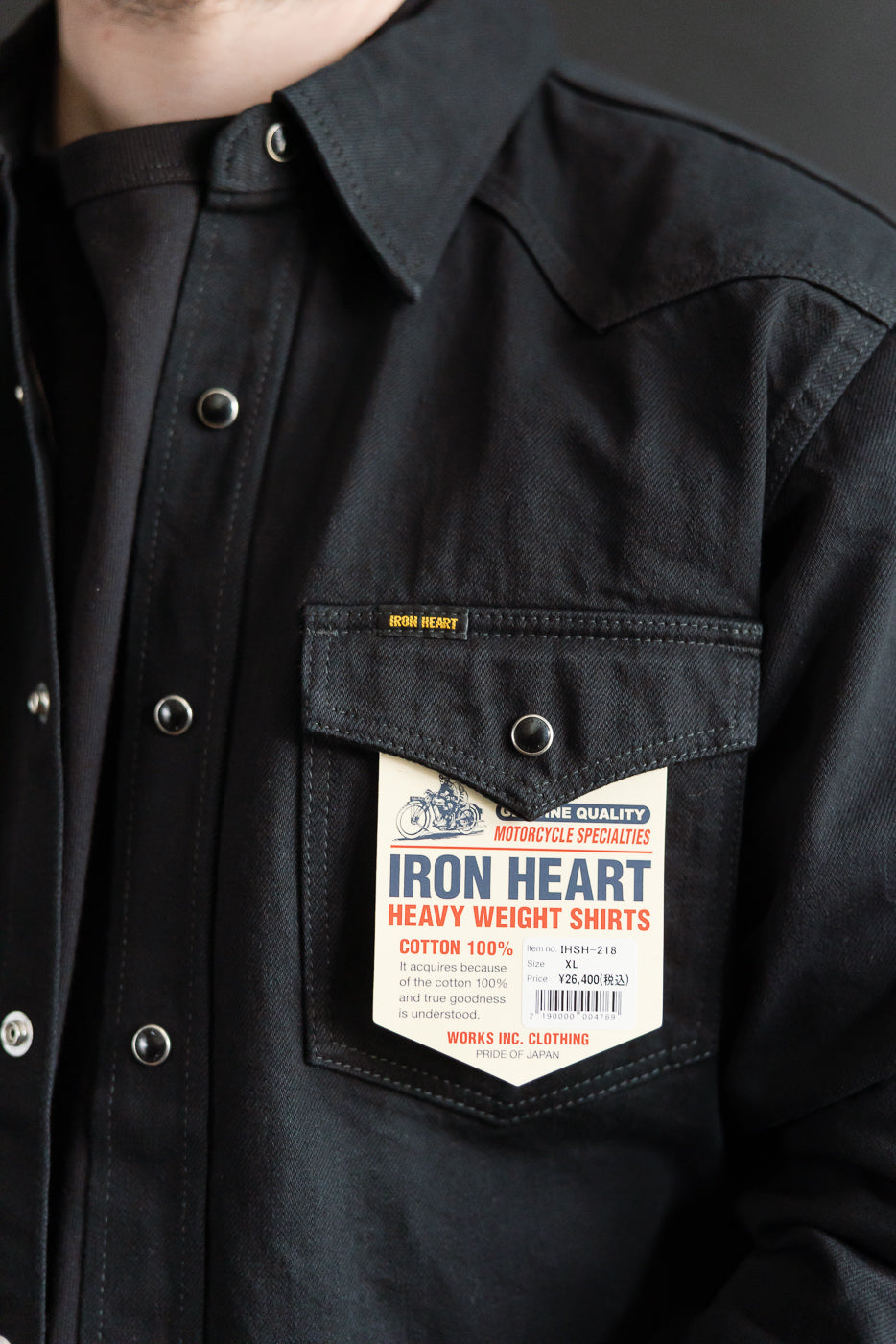 Close-up of Iron Heart IHSH-218 black selvedge denim western shirt front chest pocket, label, snap buttons, and pointed collar on male model 5'9