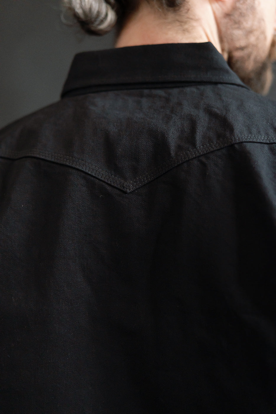 Close-up of Iron Heart black selvedge denim western shirt back yoke on male model
