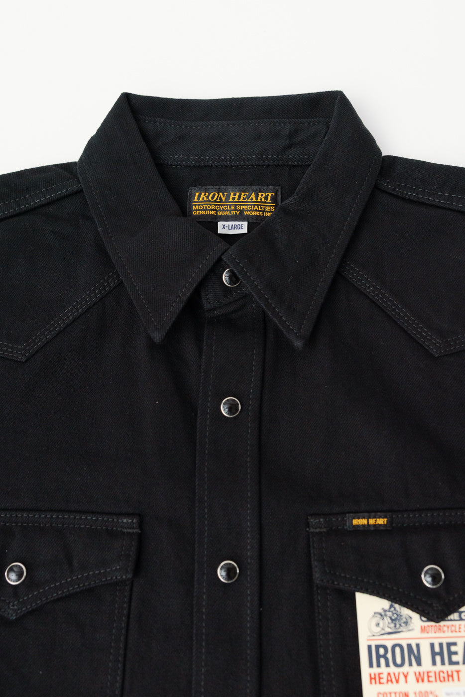Close-up front of Iron Heart IHSH-218 black selvedge denim western shirt, snap buttons, collar, chest pockets, tag detail.