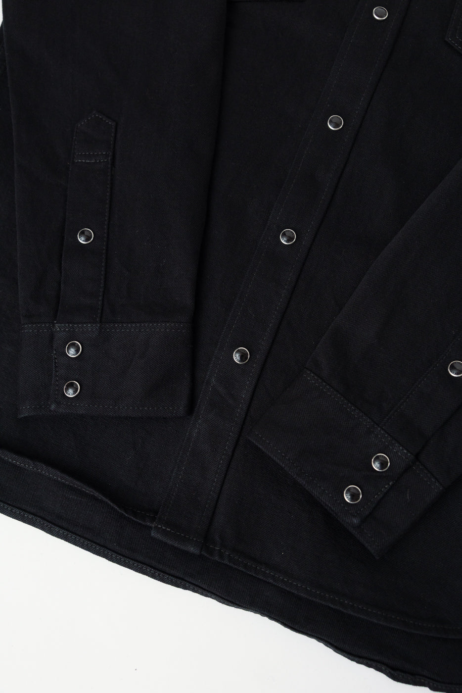 Close-up of Iron Heart IHSH-218 black selvedge denim western shirt front hem, cuffs, snap buttons, and sleeve details