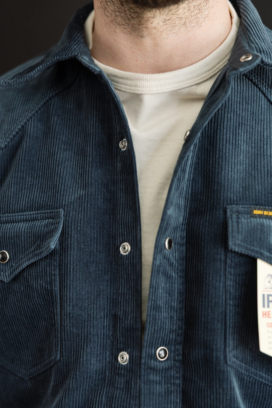 Close-up front view of navy corduroy western shirt on male model, 5'9