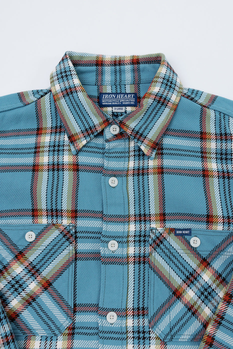 Close-up front view of men's plaid shirt with button-down collar, chest pockets, and brand tag