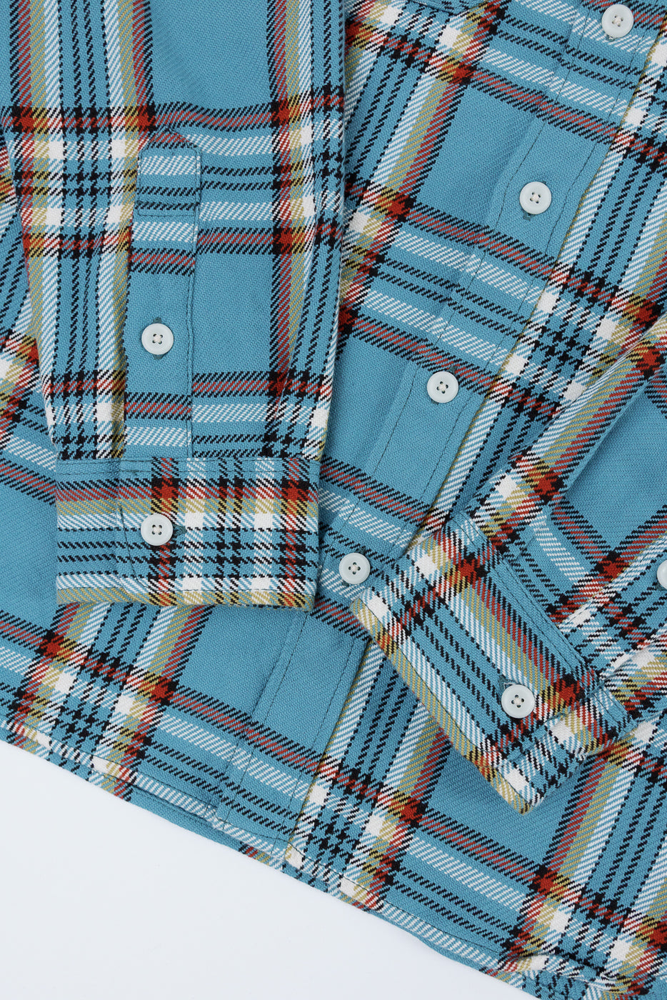 Close-up front view of blue plaid shirt with white buttons, chest pockets, and detailed fabric texture