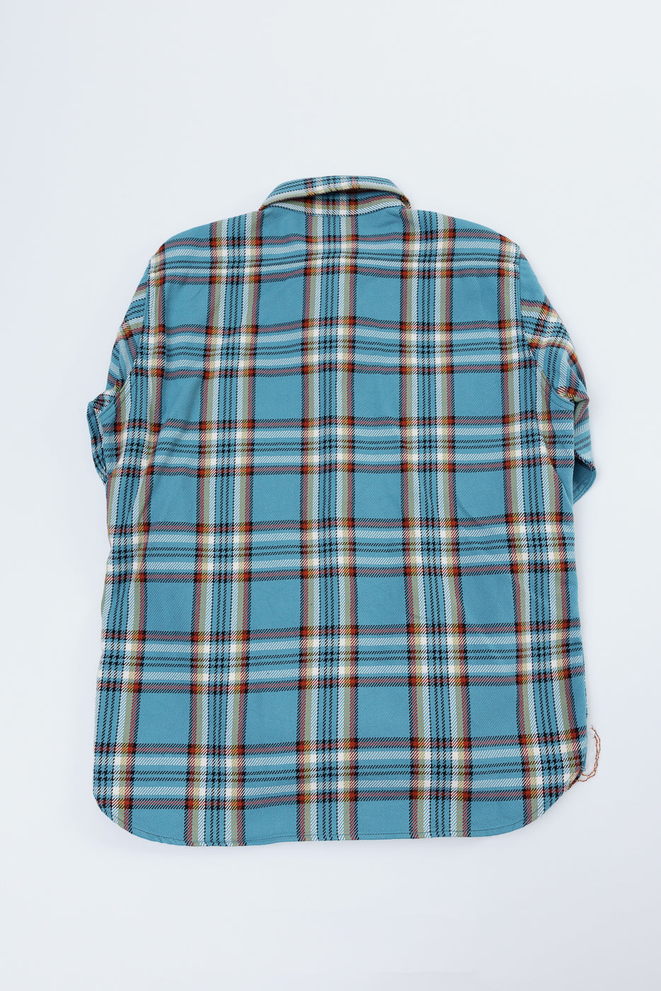 Back view of blue plaid shirt with rolled sleeves, showcasing fabric texture and hem detail