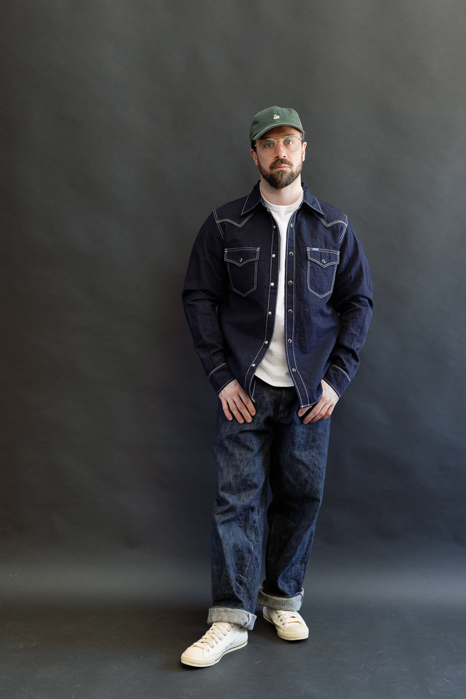 Man wearing the IHSH-444-IND - 7oz Cotton Linen Chambray Western Shirt in indigo, styled with a white t-shirt and loose-fit blue jeans, showcasing its classic western cut and meticulous craftsmanship.