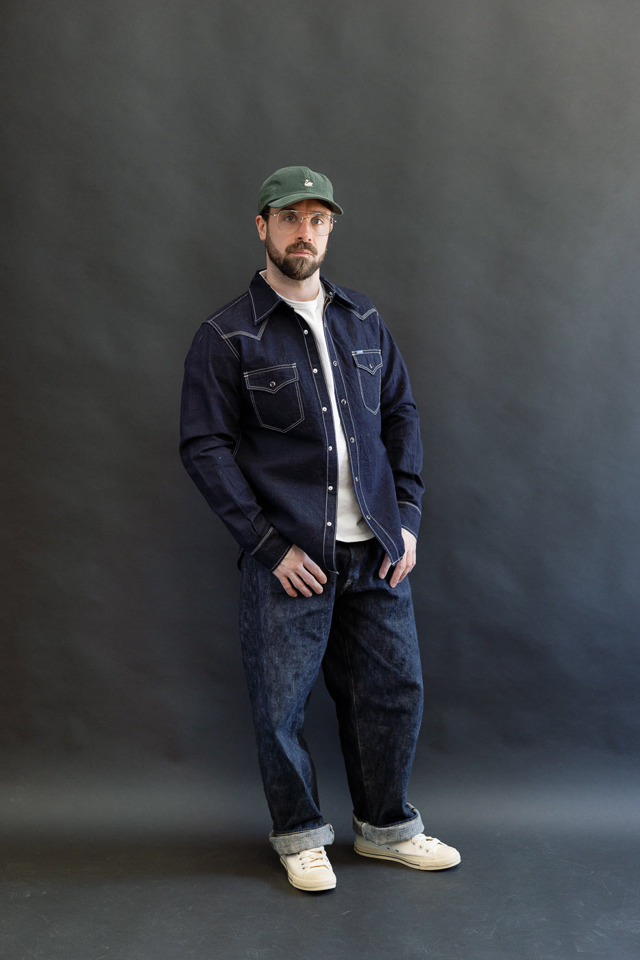 Model wearing the IHSH-444-IND - 7oz Cotton Linen Chambray Western Shirt in indigo, styled over a white t-shirt and paired with dark denim jeans and off-white sneakers.