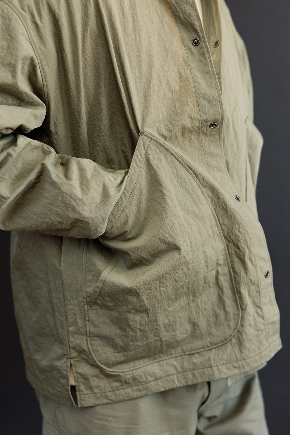 Close-up, side view of olive green jacket on athletic male (5'9
