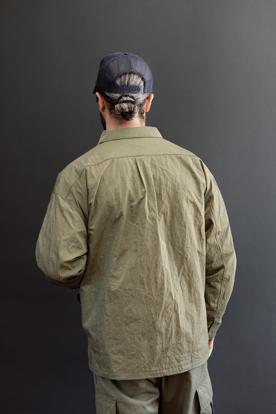 Back view of olive green casual shirt on a 5'9