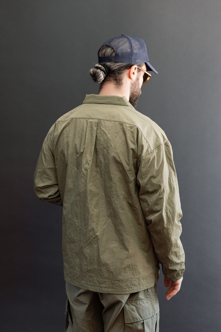 Full body back view of olive casual shirt on male model, 5'9