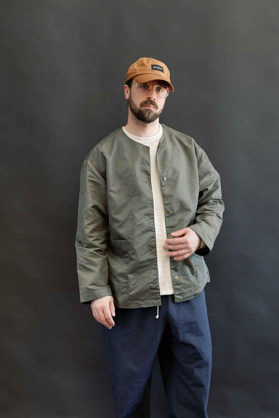 Front view of olive collarless jacket on male model 5'9