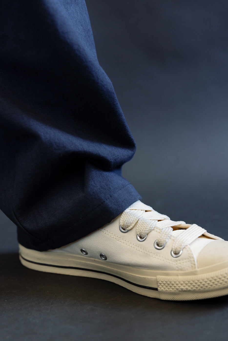 Close-up of men's navy canvas rookie pants hem, side view on male model, highlighting fabric texture.