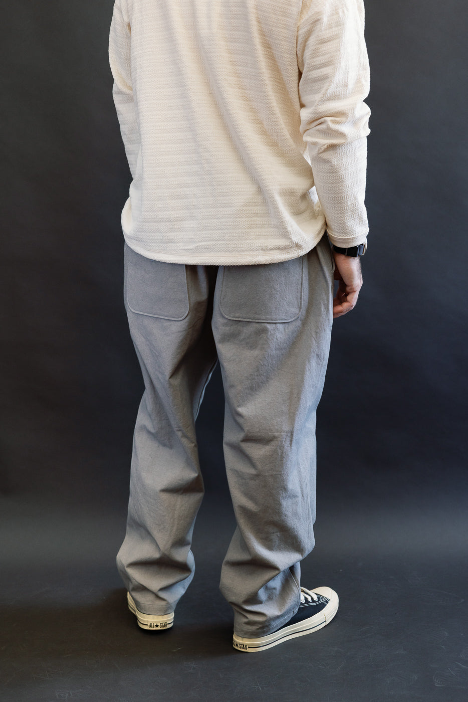 Back view of gray canvas pants on male model 5'9