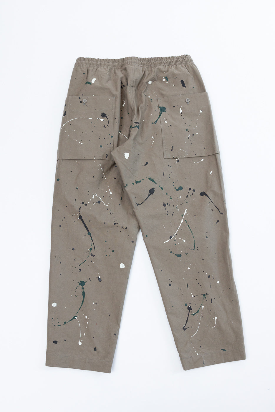 Flat lay of the back of taupe paint-splattered cargo pants with rear pockets.