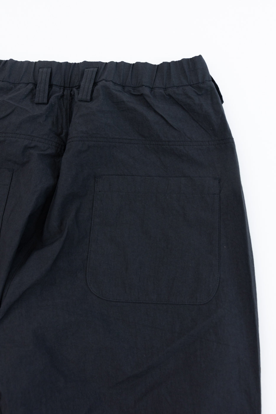 Black casual pants back view: elastic waist, rear pocket, flat lay close-up