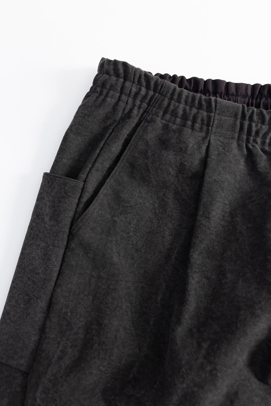 Close-up of black Jackman Sumi UMP pants front, showing pocket and elastic waistband texture