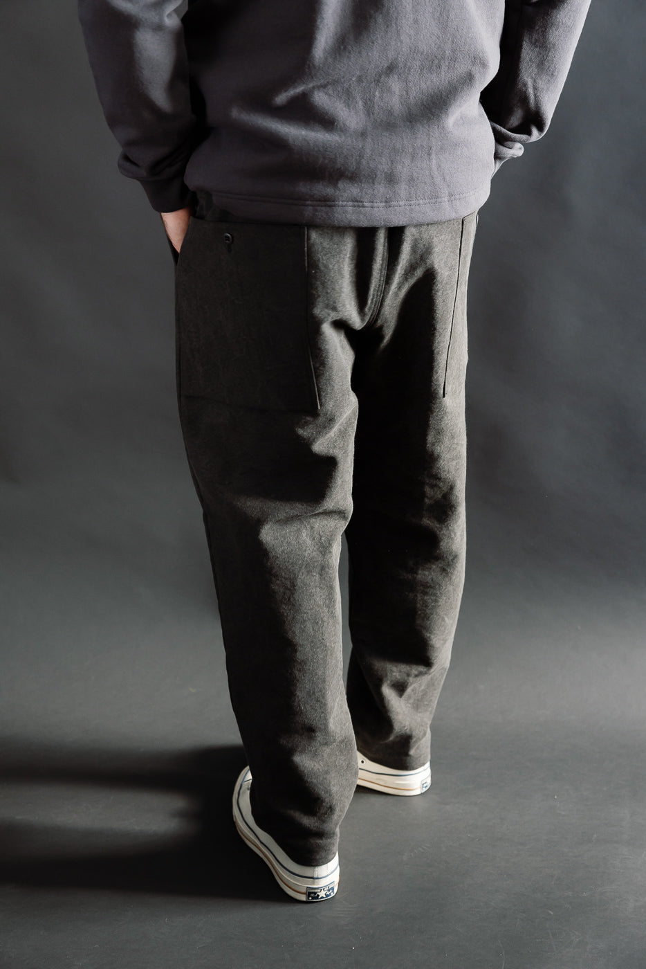 Back view close-up of men's black pants on male model, 5'9